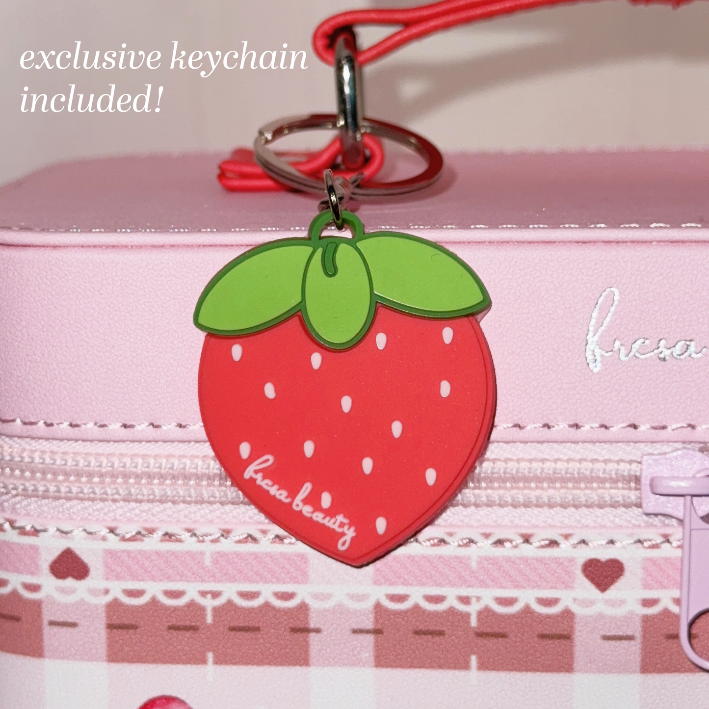 Strawberry-shaped keychain on a pink background with text 'exclusive strawberry keychain included!'