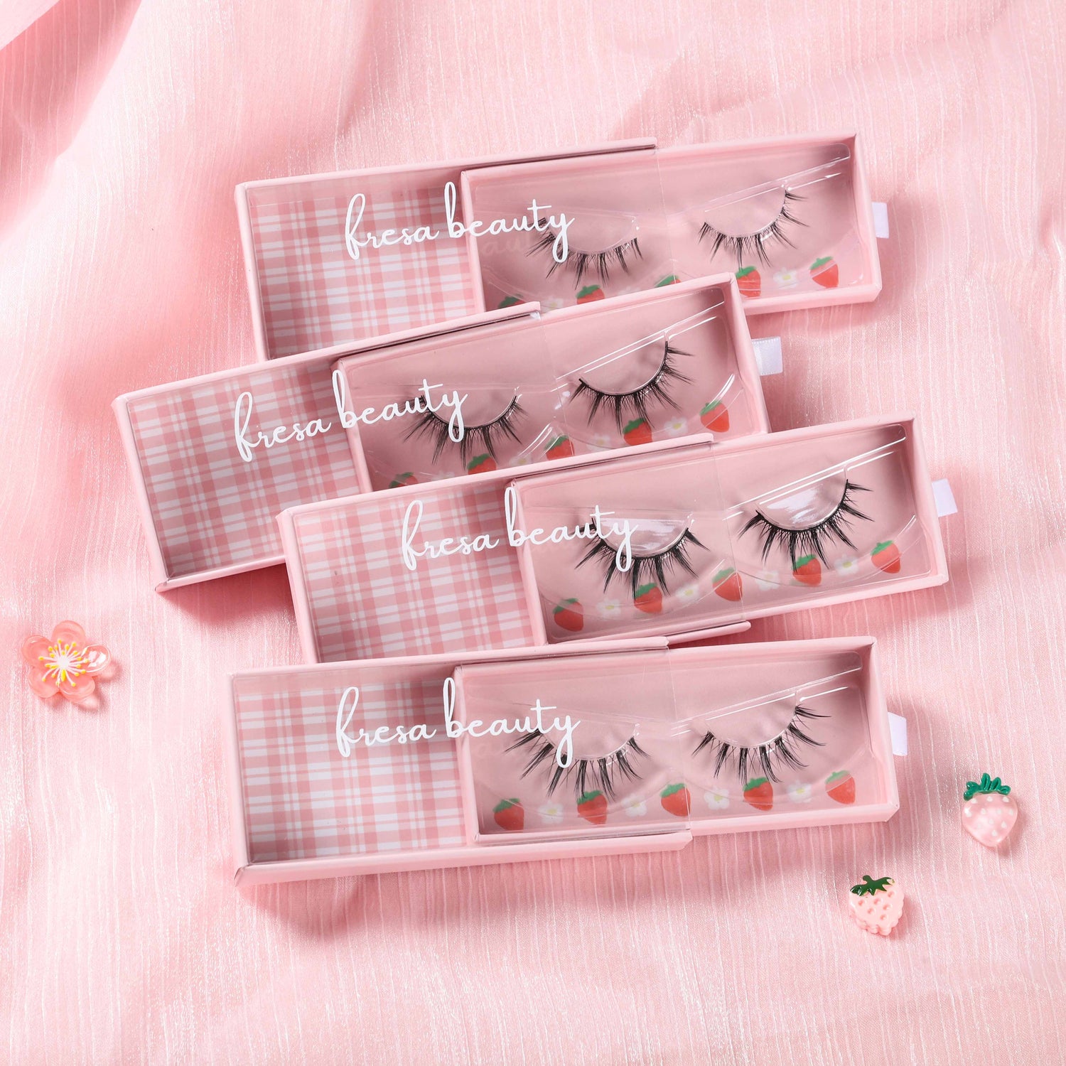 Four Lash Single Packs Spread Together Over Pink Fabric.