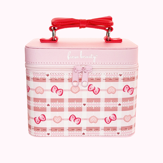 Pink and gingham print cosmetic case with a red bow handle and zipper closure.