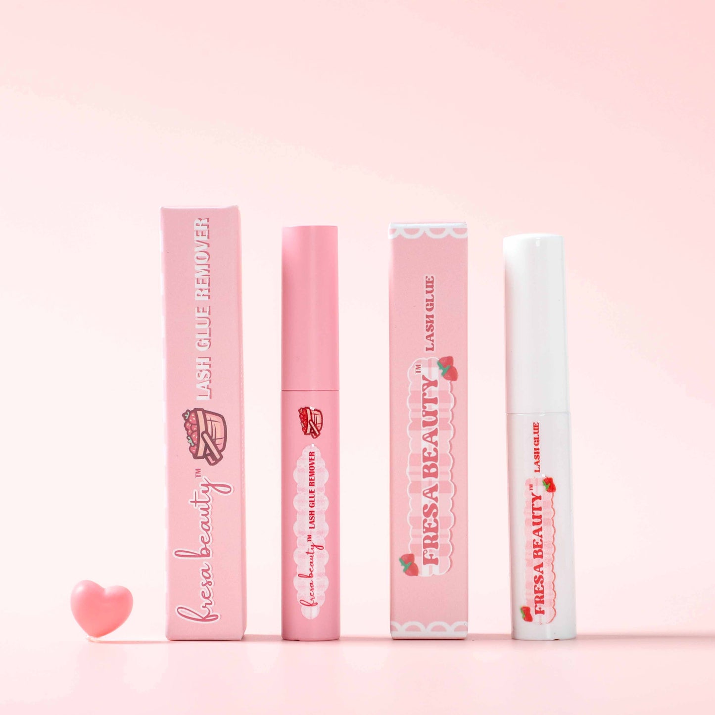 Fresa Beauty Pink Makeup Remover Tube with a White Lash Glue Tube on a Pink Background
