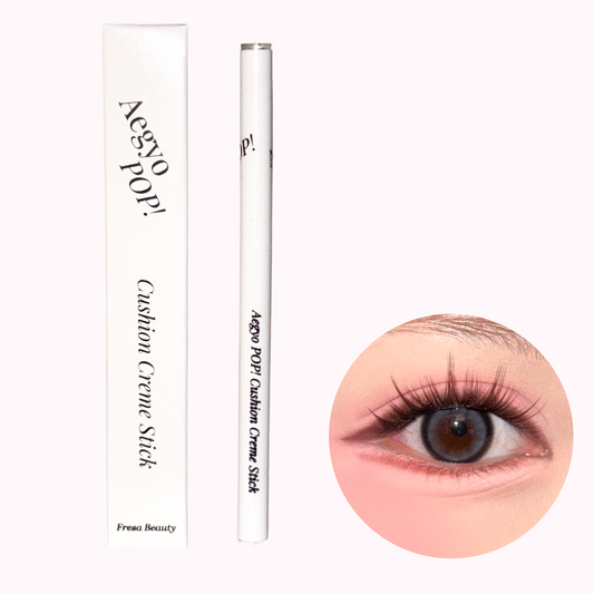 A white cosmetic pencil and its matching box for an Aegyo Pop! Cushion Creme Stick by Fresa Beauty, shown next to a circular insert demonstrating the makeup applied to an eye.